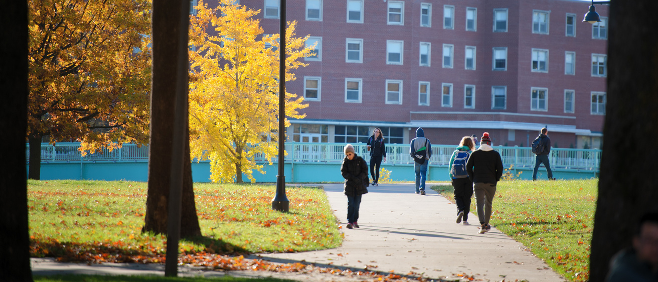 campus in the fall with yellow trees and students walking to class
