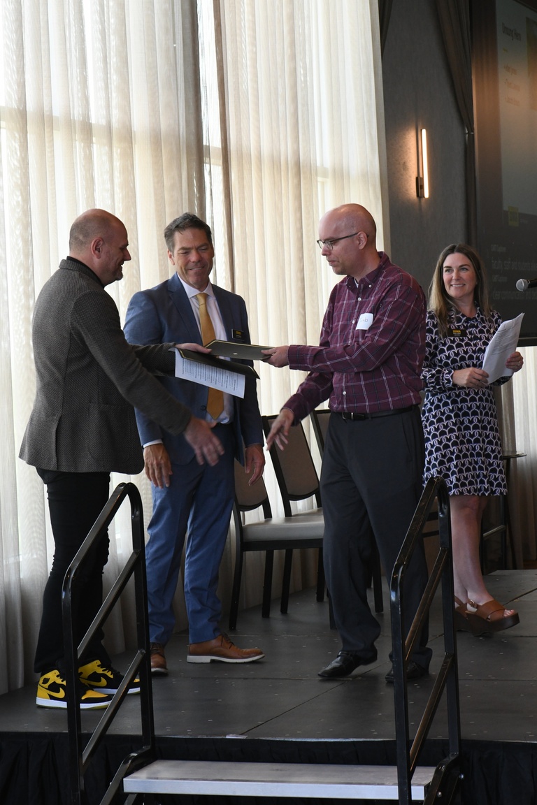 Jacob Braun, database architect for HCIS, receives the Unsung Hero Award from Josh Wilda and Brad Rohrer. 