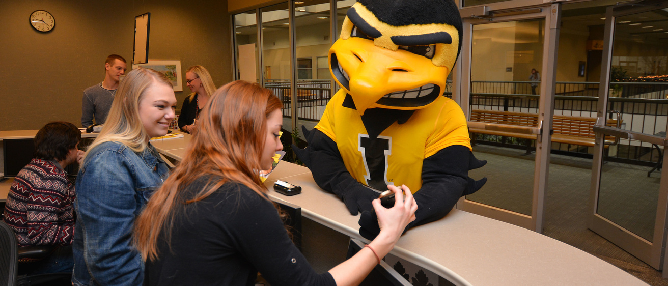 Herky talking to ITS help desk staff at the walk-in desk