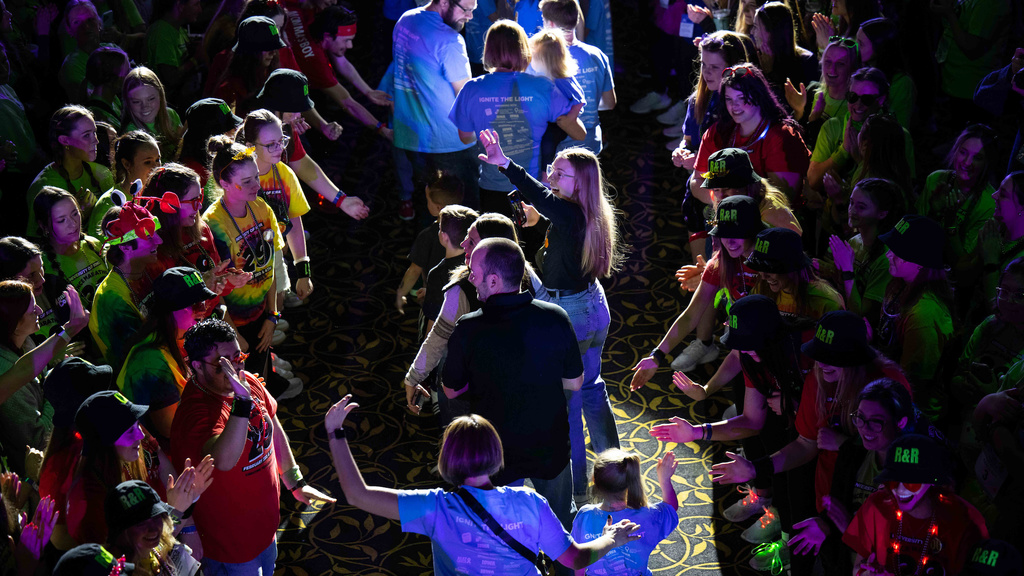 Students line up to wave and give high-fives at Dance Marathon 2023 making a path as children and parents walk by