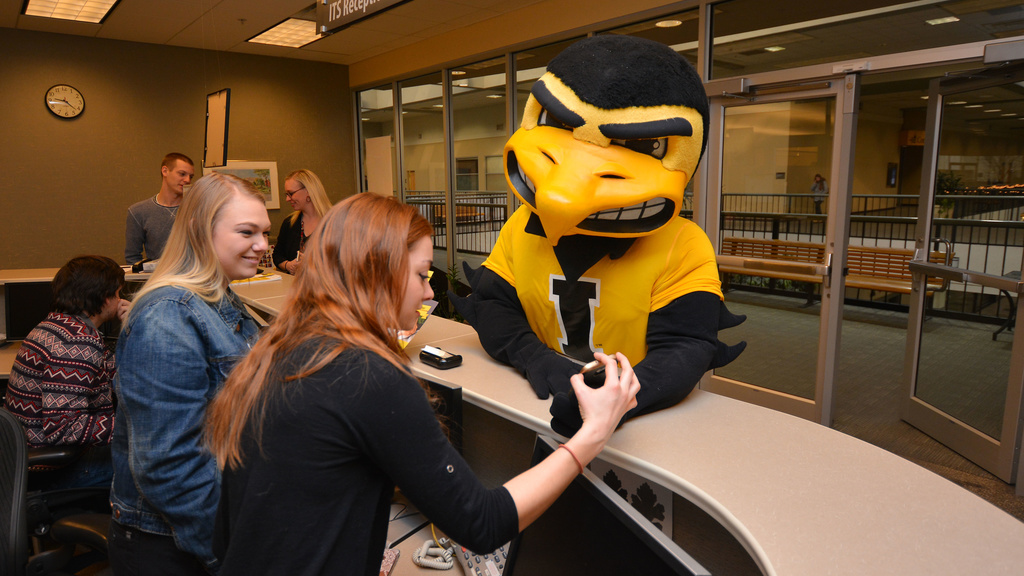 Herky talking to ITS help desk staff at the walk-in desk